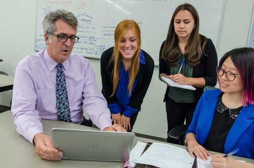 Students and mentor working around a computer