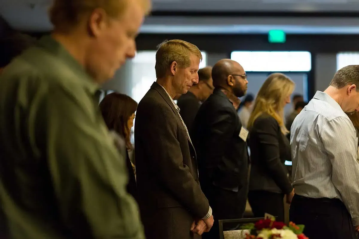 Attendees bowing their heads for prayer