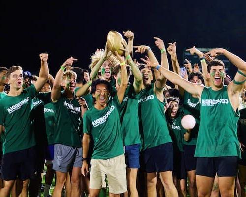 A group of people cheering and holding up the Golden Egg