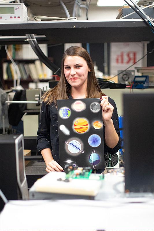 Susan Eschelbach holding one of her pieces in the science lab